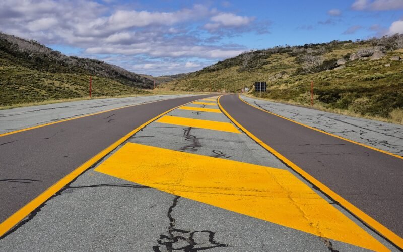 Empty sealed road winding through alpine countryside in Kosciuszko National Park