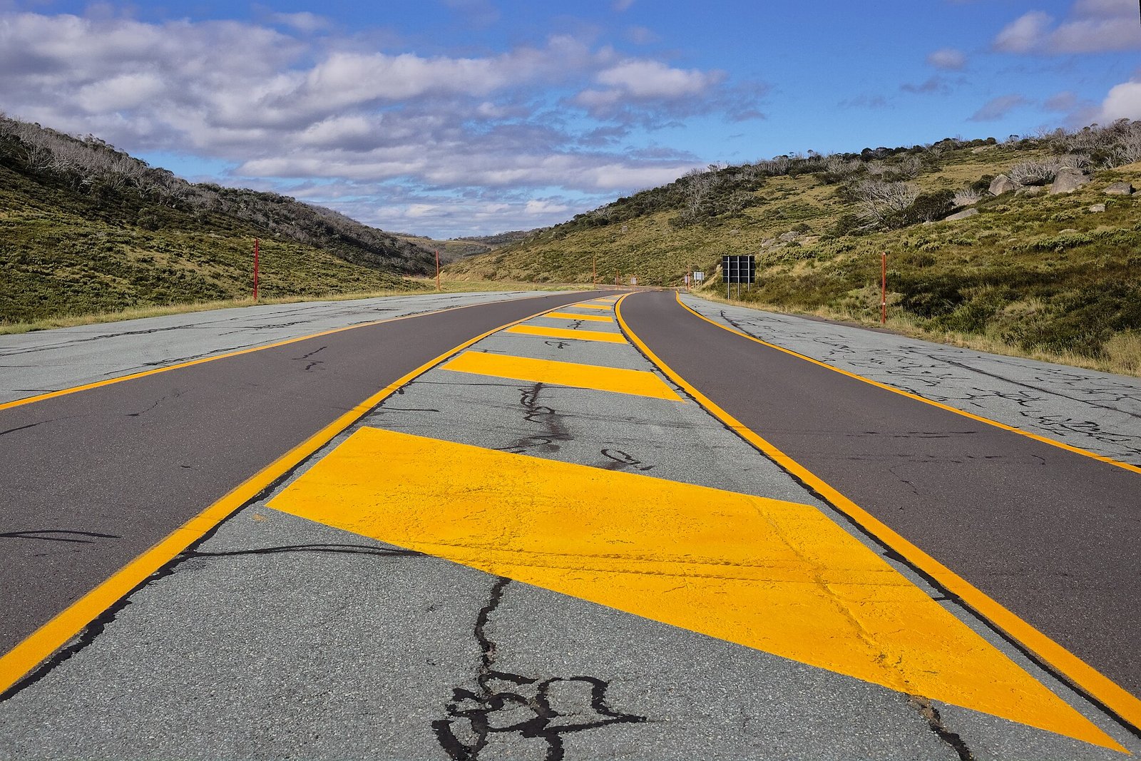 Empty sealed road winding through alpine countryside in Kosciuszko National Park