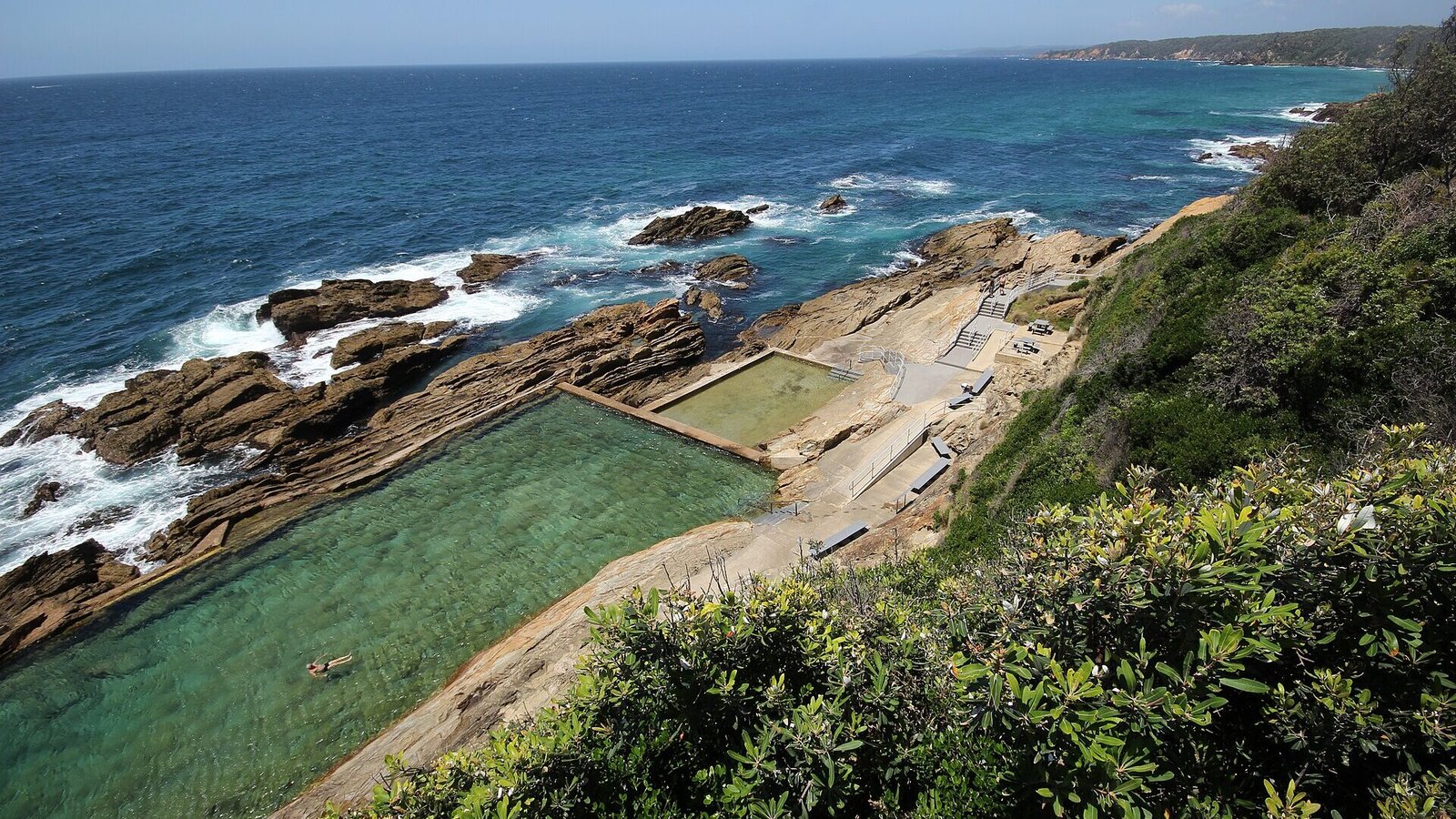 The Blue Pool ocean pool carved into the rock shelf below the headland at Bermagui NSW