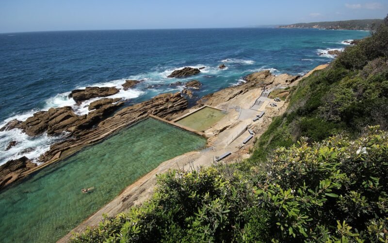 The Blue Pool ocean pool carved into the rock shelf below the headland at Bermagui NSW