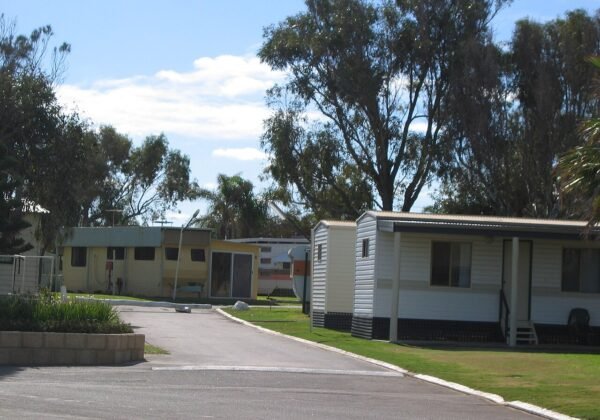 Caravans and holiday cabins among trees at an Australian caravan park