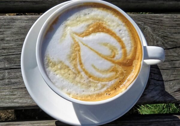 A flat white coffee with latte art on a cafe table