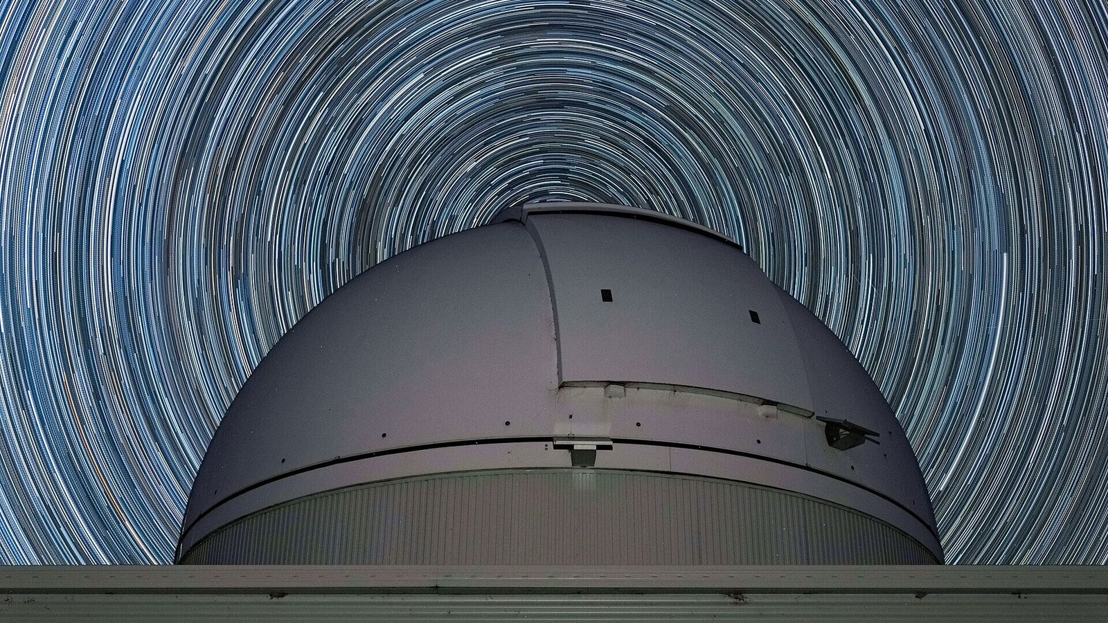 Star trails over an observatory dome in rural NSW